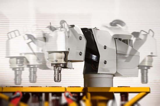 Braço robótico em operação em um ambiente industrial, destacando tecnologia de ponta e automação nos processos de manufatura.