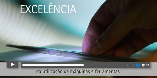 Mão segurando um dispositivo eletrônico com tela brilhante e texto 'EXCELÊNCIA', destacando o uso de tecnologia em máquinas e ferramentas