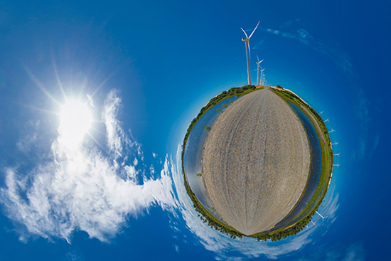 Imagem criativa em formato de planeta pequeno, little planet, mostrando turbinas eólicas em uma paisagem surreal, destacando energia renovável.